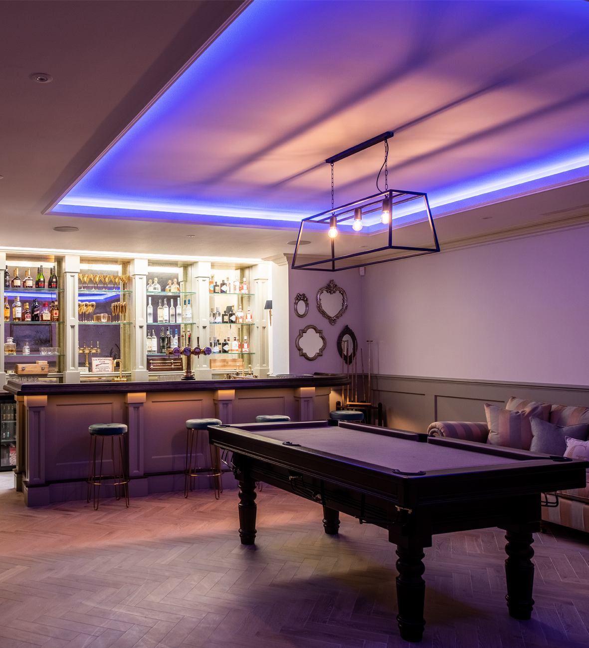 Luxury home entertainment room with pool table, bar, and ambient lighting design
