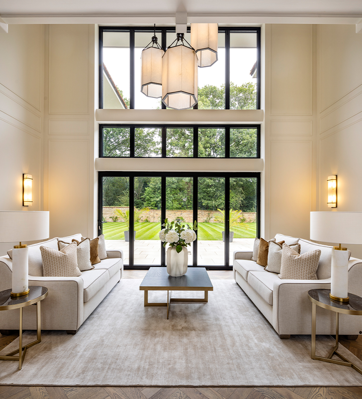 Luxury living room with modern lighting design, large windows, and elegant AV setup for smart home integration.