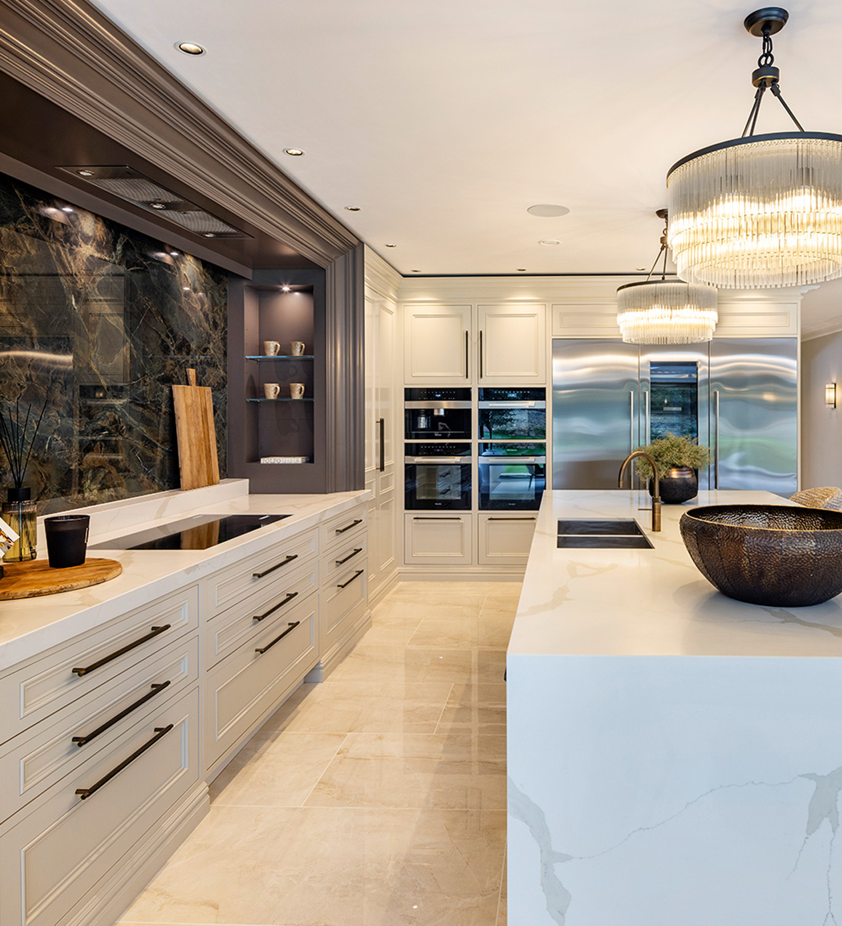 Luxury kitchen with marble countertops, modern lighting, and integrated appliances