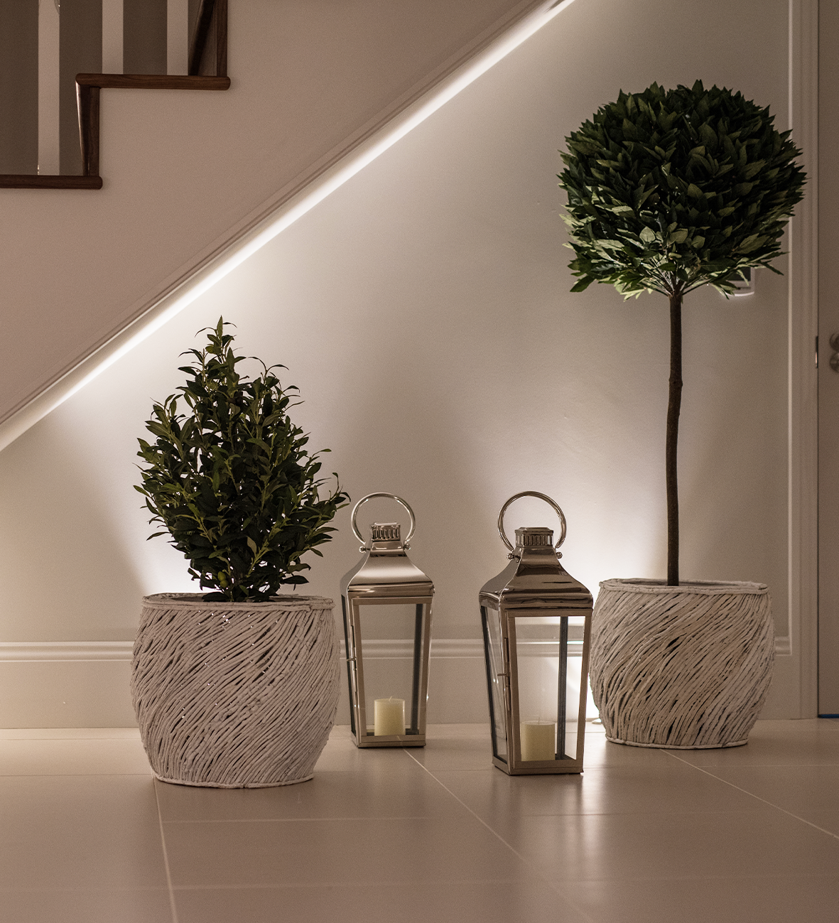 Modern hallway with LED strip lighting, potted plants, and decorative lanterns for ambient home lighting design